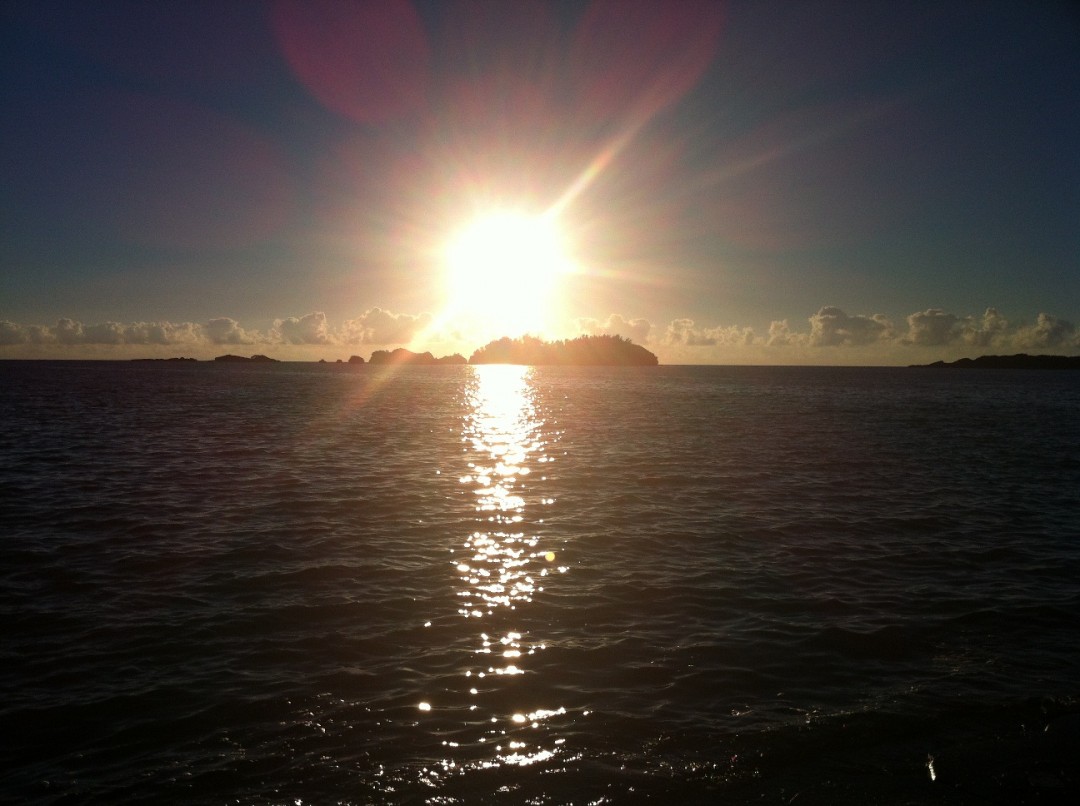 海の上から撮影した南恩納海岸から望む夕日の画像（別ウィンドウで開く）